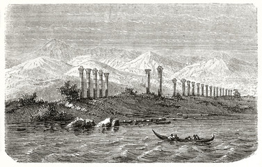 Ancient greek columns alone on a land viewed from the sea. Mountains back in the distance and canoe sailing in the foreground water. Aratus' tomb in Pompeiopolis Turkey. Le Tour du Monde Paris 1862