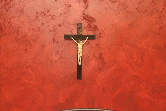 Crocifisso su parete rossa