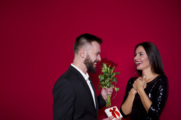 My love is for you. Beautiful young couple in love on a red background. Valentine's Day. Women's Day. March 8