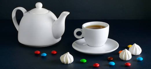 Obraz na płótnie Canvas White cup and teapot on a black background.