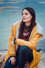 Young female sitting with siberian husky dog in mountains