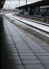 Fototapeta premium Empty railway station platform with watch and perspective railroad. Travel and tourism concept. Winter journey. Transport background.