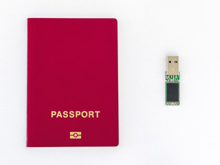 Usb flash drive and red passport on a white background.