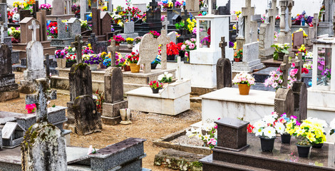 Cemitério com túmulos e flores.