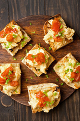 Toasted bread with scrambled eggs, tomato and green onion
