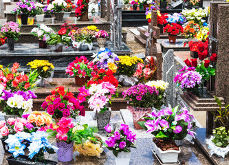 Cemitério com túmulos e flores.