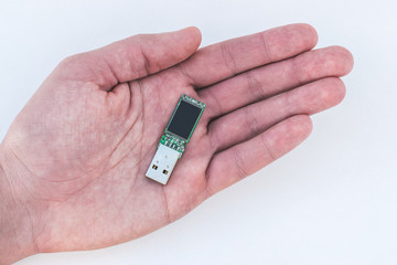 USB flash drive in hand on a white background.