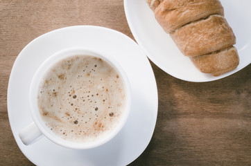 Cappuccino or coffee latte and croissant.