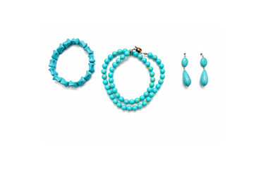 Bracelet, pendants and beads made of turquoise on a white background.