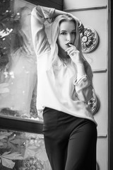 Beautiful fabulous woman in black pants and white shirt. Fashionable and elegant look.