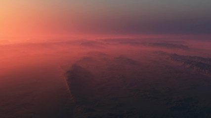 Overhead shot of misty rocky desert at sunrise.