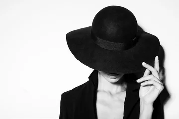 High-Fashion-Porträt einer eleganten Frau in schwarz-weißem Hut und Kleid. Studioaufnahme © forget_me_not_18