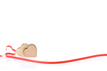 Two hearts. Two wooden hearts and festive red ribbon on a white background, Valentines Day. Celebration background