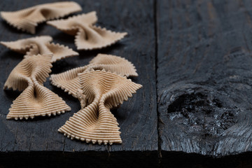 Vollkorn Farfalle Nudel auf dunklem rustikalen Holz