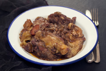 chicken prepared with red wine in white plate