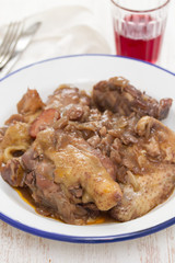 chicken prepared with red wine in white plate