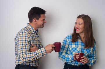 Flirting between colleagues cute young man smiling and talking with charming positive woman during coffee break on white background