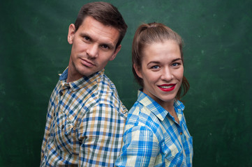 Close up portrait of middle aged couple. Positive beautiful woman with red lipstick and  manly handsome man in casual clothes on green peasant background