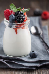 Homemade Panna Cotta with berries and mint in jar