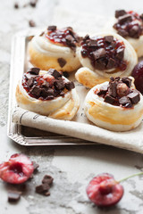 Homemade rolled cinnabon buns with cream cheese, jam, cherry and chocolate