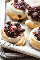 Homemade rolled cinnabon buns with cream cheese, jam, cherry and chocolate