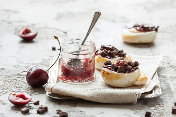 Homemade rolled cinnabon buns with cream cheese, jam, cherry and chocolate