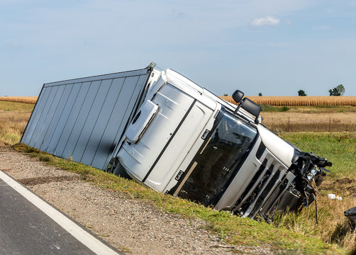 The truck lies in a side ditch after the road accident.