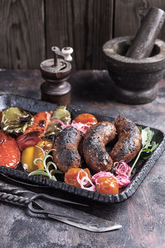 Rustic homemade sausages with grilled vegetables on table
