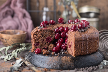 Double chocolate cherry cake with spices on the rustic background for winter holidays. Christmas and New Year decoration