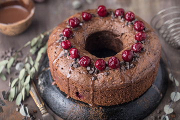 Double chocolate cherry cake with spices on the rustic background for winter holidays. Christmas and New Year decoration