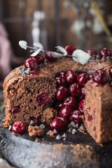 Double chocolate cherry cake with spices on the rustic background for winter holidays. Christmas and New Year decoration