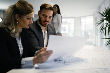 Young attractive architects working on project in office
