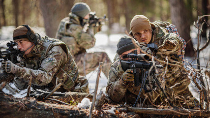 Army sniper during the military operation in the winter forest.