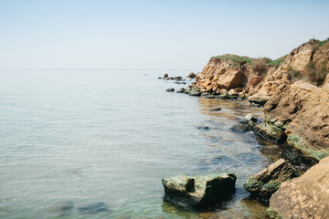 Large rocks hang over the sea