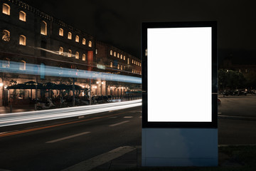 Blank white advertisement lightbox in at night. Mock-up design. Colourful car light lines.