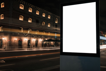Blank white advertisement lightbox at night. Mock-up design. Car light lines.