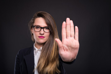 Serious businesswoman gesturing stop sign