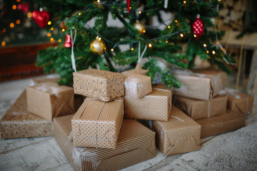 the New Year's gifts lies under a festive Christmas tree, presents are packed