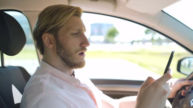 Man scrolling and checking smartphone while in a car and yawns