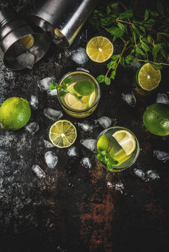 Homemade lemonade or mojito cocktail with fresh lime and mint leaves, dark rusty metal background, copy space top view