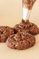 Process of Cream decoration chocolate oatmeal cookies. Cooking oats cookies.