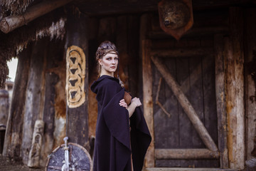 Viking woman with sword in a traditional warrior clothes.