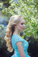 Fototapeta premium Beautiful blonde young woman wearing fashionable clothes walking in the spring park.
