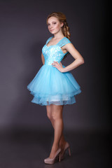 Fashion studio shot of beautiful woman with makeup and hairstyle wearing evening dress