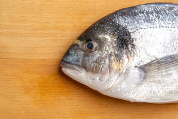  Gilt-head bream fish on the wooden cutting board