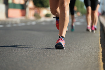 Marathon running in the light of evening,running on city road detail on legs