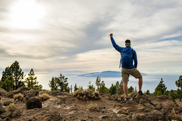 Man celebrating sunset looking at view in mountains