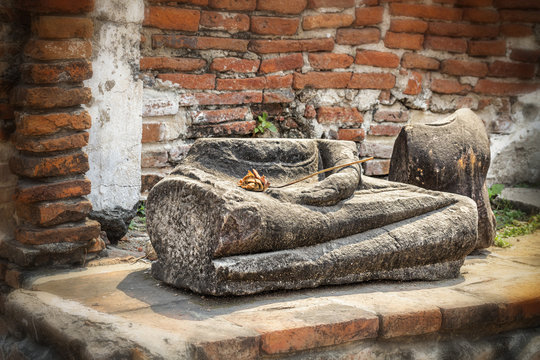 Damaged Buddha statue along a temple wall at Wat Mahathat, Temple of the Great Relic, in Ayutthaya, Thailand