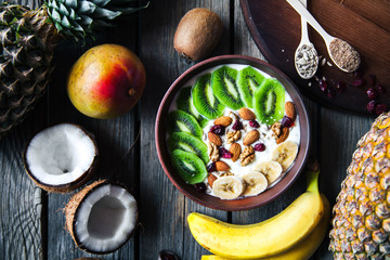 Yogurt with different fruits on a wooden background. Useful food, diet, organic.