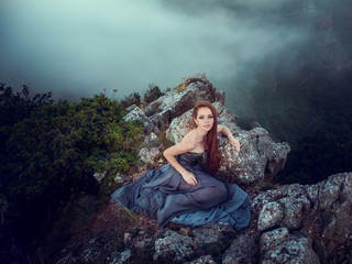 Naklejka premium Summer outdoors portrait of beautiful furious scandinavian warrior ginger woman in grey dress with metal chain mail.